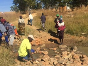 Sungano peace club members repair the makeshift bridge