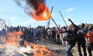 Rioters battle with Zimbabwean police in Harare. Photograph: Tsvangirayi Mukwazhi/AP