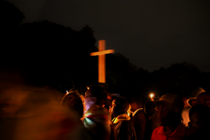 The huge crowd draws courage from prayers and the gentle, uplifting light of massed candles