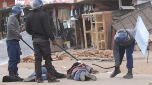 Armed Zimbabwean police beat alleged rioters in Harare, Monday, July, 4, 2016. (AP Photo/Tsvangirayi Mukwazhi)