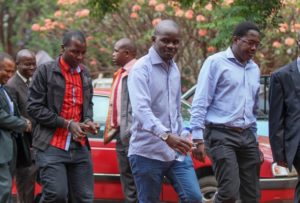 Journalists from the weekly Sunday Mail as they were arrested on Nov. 4, 2015 on charges of reporting falsehoods. Pictured from left to right in handcuffs are the journalists, who included the Sunday Mail reporter Tinashe Farawo, the paper's investigations editor Brian Chitemba and The Sunday Mail editor Mabasa Sasa. Credit: Jeffrey Moyo/IPS