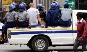Activists in a police truck in Harare. They were detained before a protest against government plans to introduce a new currency. Photograph: Philimon Bulawayo/Reuters